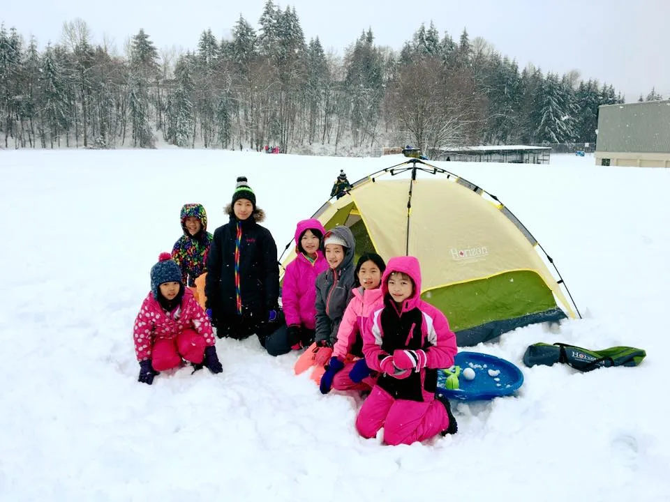 Children gathered beside a Horizon tent in the snow